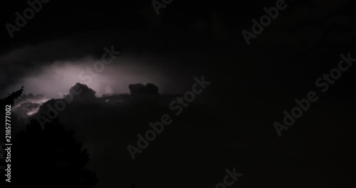 Time lapse of dark storm clouds illuminated by frequent lightning strikes during a nighttime thunderstorm.