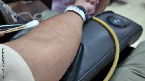 A nurse disinfects a donor arm before blood donation.