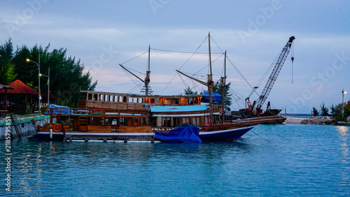 Foto Dock Traditional Wooden Sailing Ship Moored at Harbor Pier Beside Crane Barge at