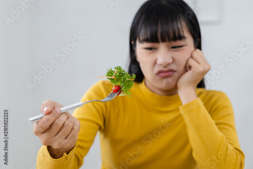 Fotografía Woman looking reluctant while eating fresh vegetable salad at home, healthy lifestyle concept for food preference, nutrition choices, healthy eating habits, wellness, vegetables and balanced meals