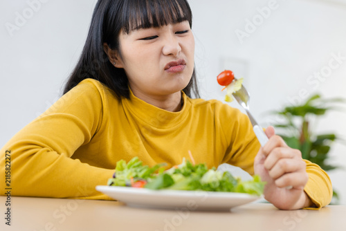 Fotografía Woman looking reluctant while eating fresh vegetable salad at home, healthy lifestyle concept for food preference, nutrition choices, healthy eating habits, wellness, vegetables and balanced meals
