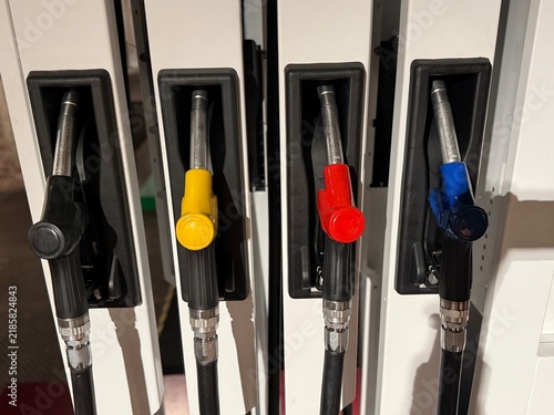 Konstfotografi Four colorful fuel nozzles mounted in a row at a self service gas station pump