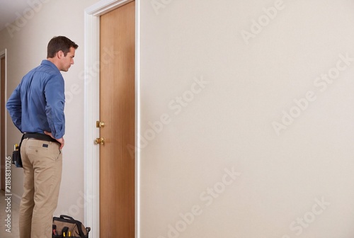 Residential Maintenance Specialist Checking Door Lock Functionality for Home Security