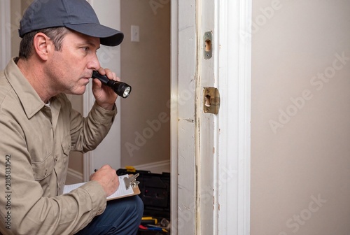 Building Inspector Evaluating Residential Door Hardware Integrity With Tools