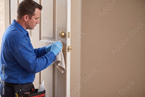 Maintenance Specialist Disinfecting Residential Door Hardware With Cleaning Cloth