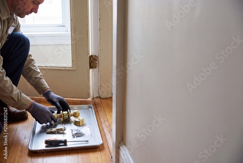 Worker Assembling Brass Door Lock Components on Residential Floor