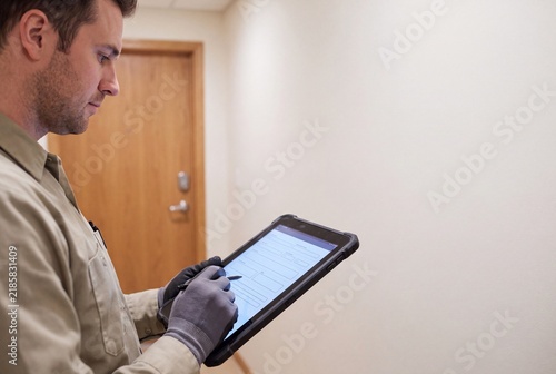 Maintenance Worker Reviewing Property Inspection Checklist on Digital Tablet