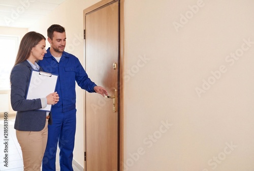 Property Manager and Maintenance Technician Reviewing Residential Apartment Entryway