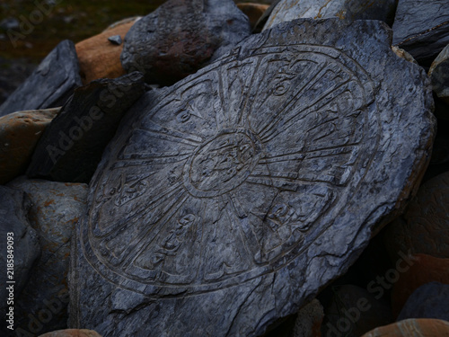 Bild auf Leinwand Ancient stone carving of a Buddhist prayer wheel on the Annapurna Circuit in the