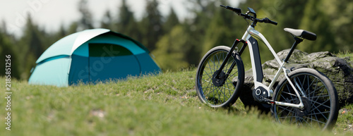 Electric bicycle parked next to a tent in a grassy field with trees in the background