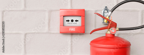 Fire alarm and extinguisher ready for emergency response on a brick wall
