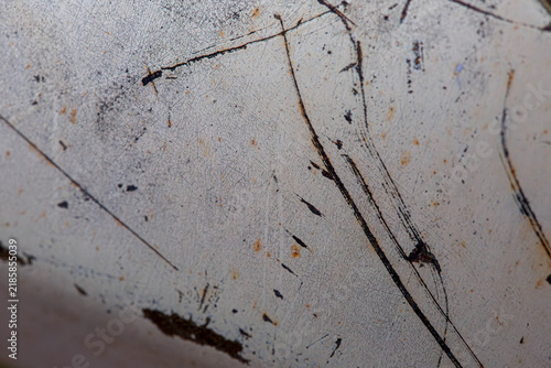 Close-up of a weathered painted metal surface with scratches, marks and signs of wear, creating an aged industrial texture.