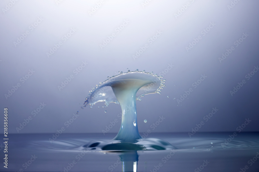 Fotografie Splash con latte e tinta azzurra