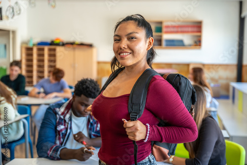 Happy teen student smiling in diverse classroom