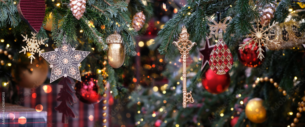 Fototapeta premium beautiful Christmas background. festive decorations, glowing garlands close up on christmas tree branches outdoor. Symbol of winter season, New Year, Christmas holiday. copy space. banner