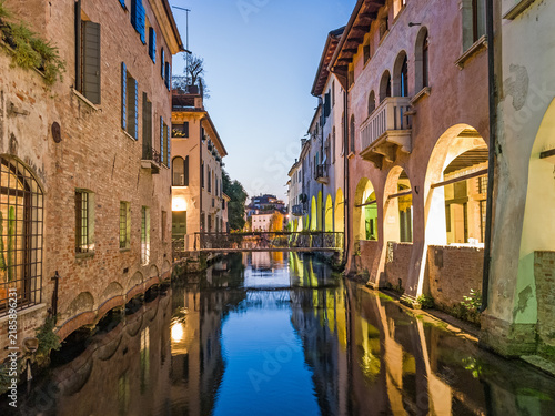 Treviso, Veneto, Italy — Botteniga river channel, bridge and old buildings at dusk