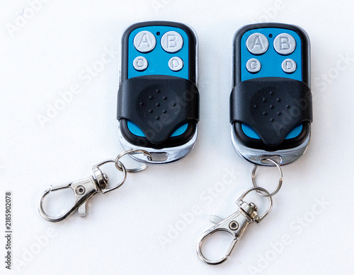 Foto Two identical blue and black garage door remote controls with keyrings
