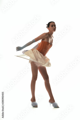 Obraz na plátně Young woman models avant-garde fashion in terracotta corset and skirt