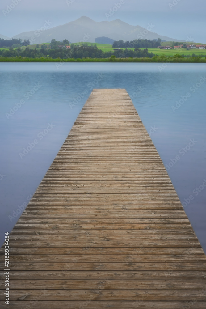 Obraz premium Wooden pier extending into Hopfensee lake in Bavaria