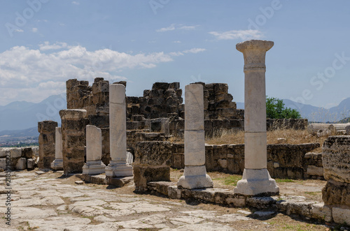 Ancient Laodicea ruins in Turkey with Roman columns, historic stone road, scenic mountains, blue sky, and archaeological heritage site landscape