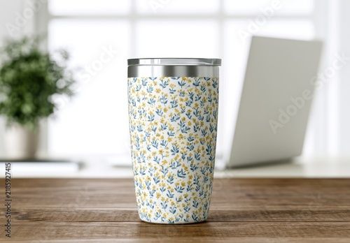 Floral patterned tumbler on wooden desk, blurred office background