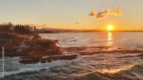Sunset over Snapper Rocks with the Gold Coast skyline in the distance, aerial drone view, Queensland Australia