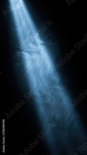 Blue light beam cutting through thick smoke against a dark background