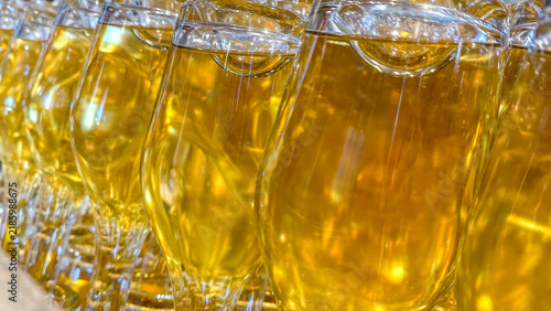 фотографія Golden liquid filling elegant glasses, preparing for a special event, showcasing