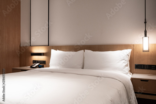 Foto modern minimalist hotel bedroom double bed with white linens and wooden headboar