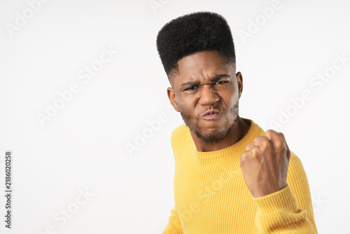 Fotografía Aggressive portrait of young man holding fists up isolated over white background
