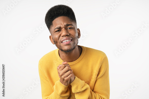Fotografie Guilty young man keeping hands together and begging for mercy, asking for help i