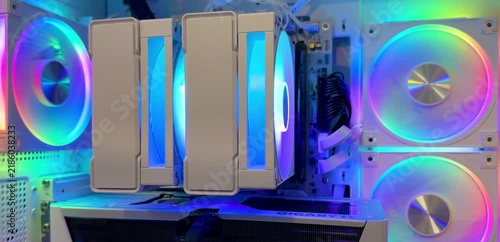 White desktop computer case with colorful RGB fans, a large CPU cooler, and graphics card visible inside. Gaming hardware, custom PC, RGB lighting, computer technology.