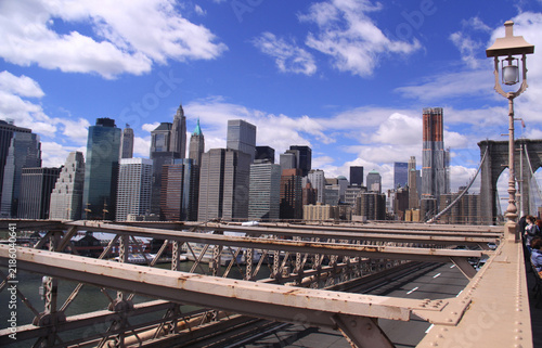 Bild auf Leinwand City skyline view with skyscrapers from a historic suspension bridge under blue