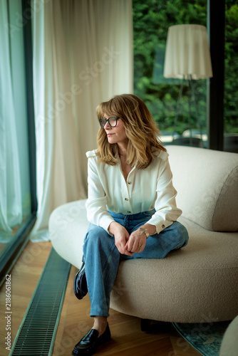 Stylish woman relaxing on sofa in a modern living room interior