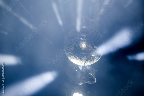 Картината върху платно Sparkling disco ball reflecting bright lights in a dark nightclub or party venue with dynamic motion blur effect
