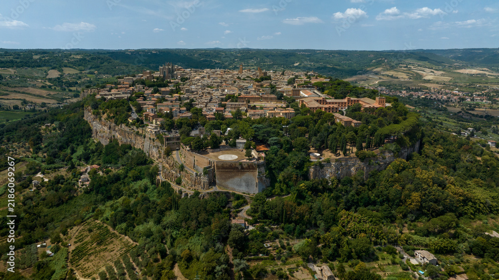 Fototapeta premium Aerial panoramic view of the historic town of Orvieto perched atop its volcanic tuff cliff, in the province of Terni, Umbria, Italy, with the Rocca Albornoz gardens visible on the clifftop edge.