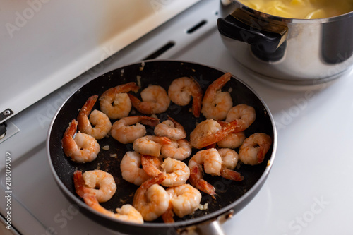 Cuadro en lienzo Pink prawns sizzle inside a black frying pan on a stove in Corfu,Greece