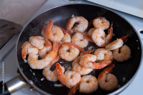Cuadro en lienzo Pink prawns sizzle in a black frying pan on a kitchen stovetop in Corfu,Greece