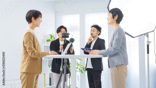 明るいオフィスで動画撮影とインタビュー収録をするビジネスチーム