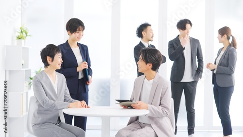 Fototapeta 明るいオフィスで打ち合わせをするビジネスチームの男女