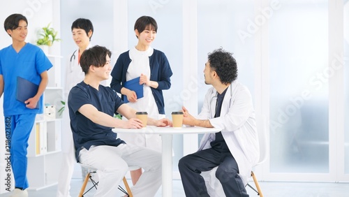 Fototapeta 病院の休憩室でコーヒーを片手に談笑する医師と医療スタッフ
