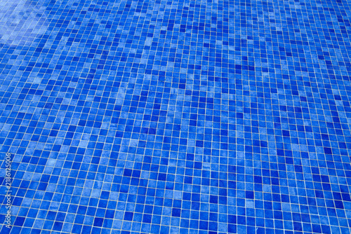 Blue tiles pool with ripple water reflection .