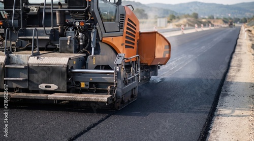 Modern Asphalt Paving Machine Laying Fresh Road Surface on New Highway