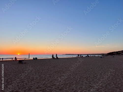 people watching the beautiful sunset at the beach Playa de La Fontanilla in Conil de la Frontera, Atlantic Ocean, Andalusia, Costa de la Luz, Spain