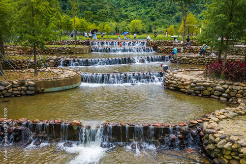 Aerial View of Happy joyful boy and girl play in water at Toupi Park, Shenzhen, Guangdong Province, China.