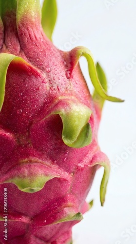 a dragon fruit surface with vivid pink scales and green tips
