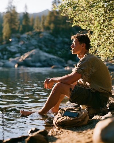 Man enjoys time by the water while engaging in a digital detox experience