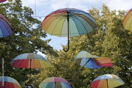 Colorful rainbow umbrellas hanging creating an artistic street decoration