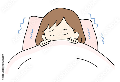 woman shivering in bed under a blanket due to chills or fever.