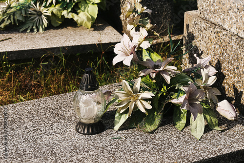 Foto Memorial candle beside artificial flowers background